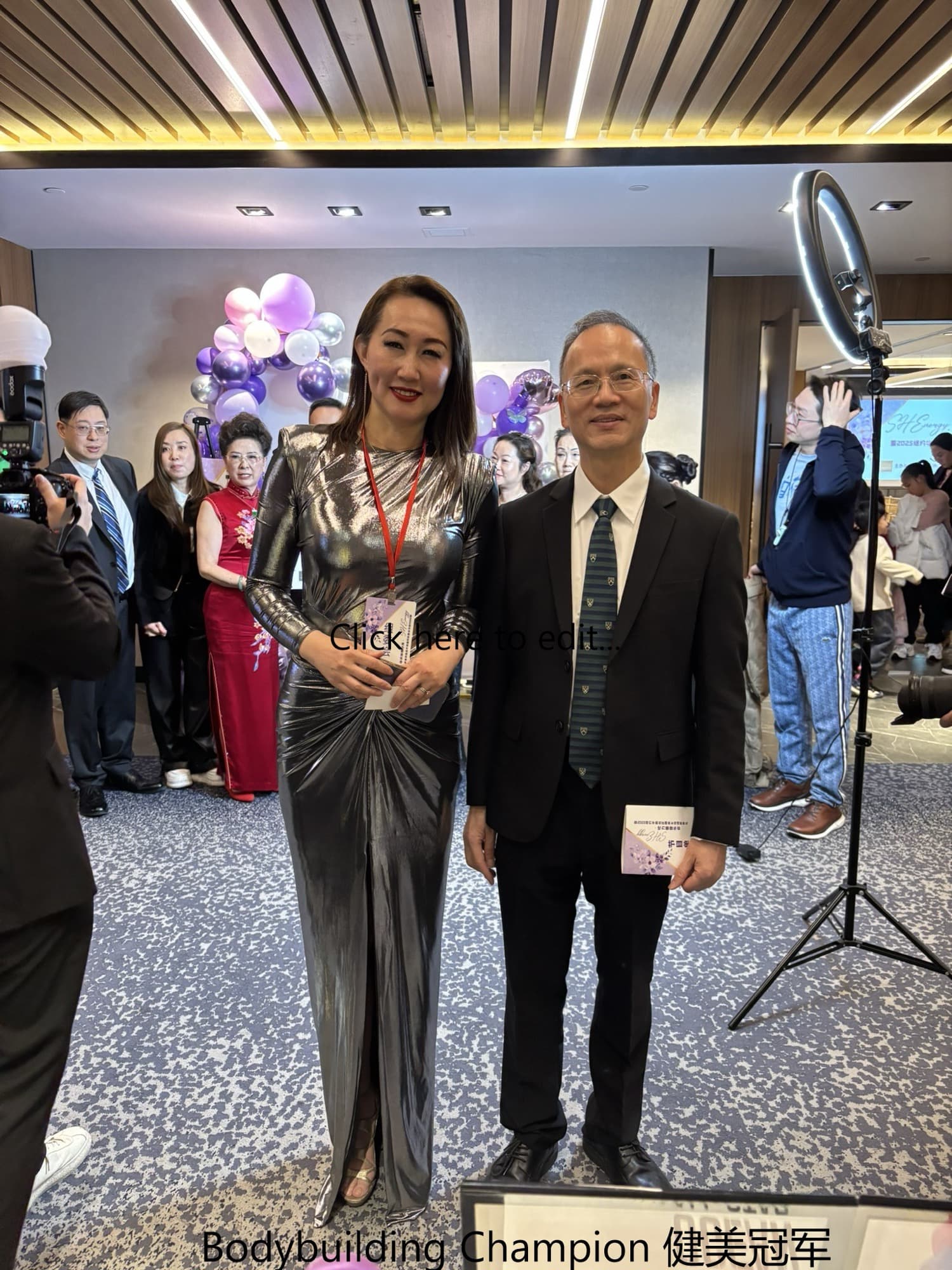 李医生身着西装与一位健美冠军女士在活动现场合影
