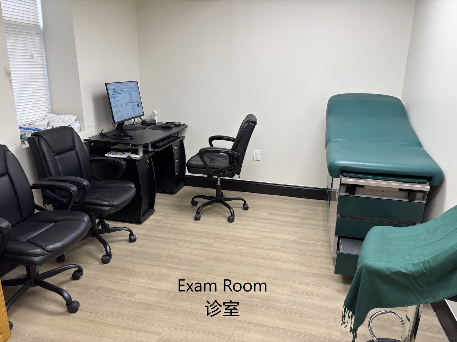 诊室内景，配绿色检查床与电脑工位