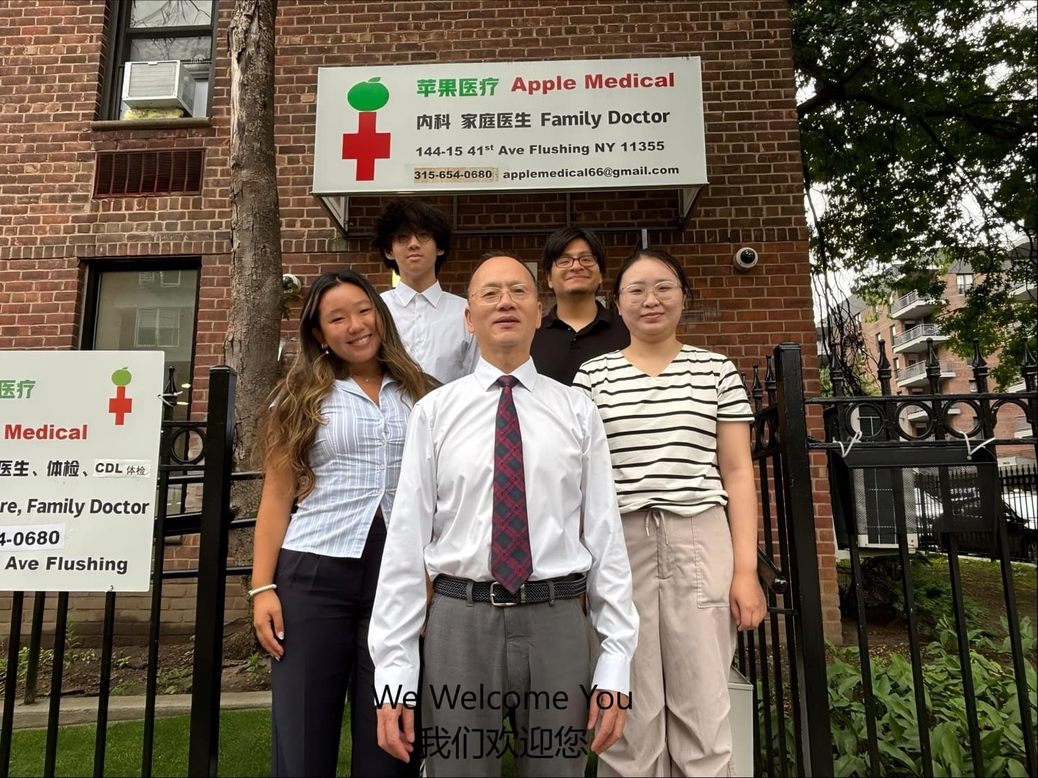 李医生与四名员工在诊所门口招牌下合影，侧招牌可见医生、体检、CDL 体检字样