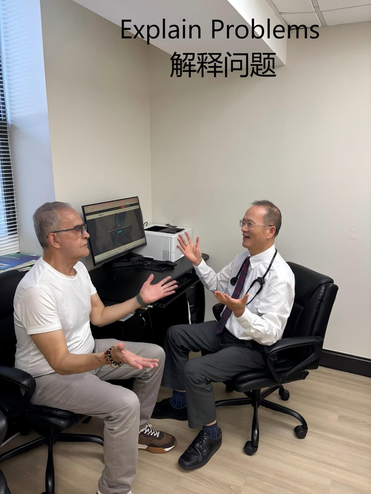 Dr. Lee in a white shirt sitting across from a patient, hands open, explaining results patiently